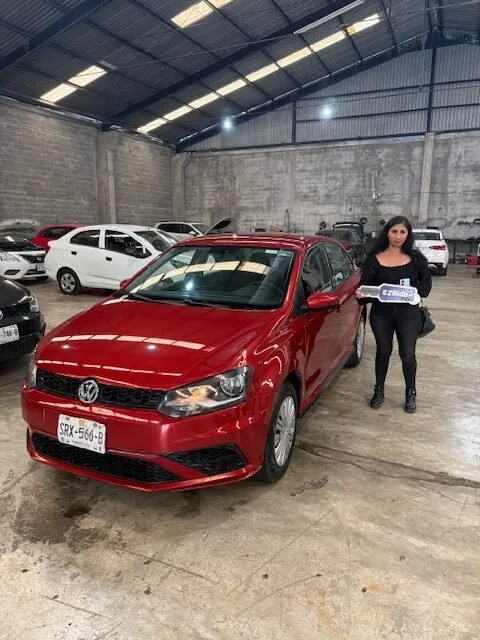 Clienta de EzRide con las llaves de su Volkswagen Polo rojo en la entrega en Monterrey