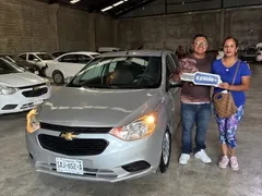 Pareja recibiendo las llaves de su Chevrolet Aveo plateado en EzRide Monterrey